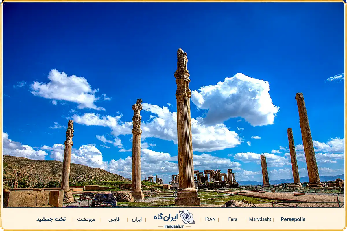 شش سرستون خالی تخت جمشید با آسمان آبی و ابرها